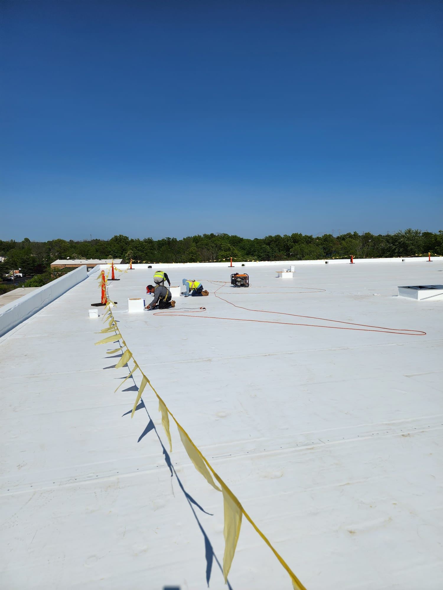 Single-ply membrane being installed on a large commercial roof